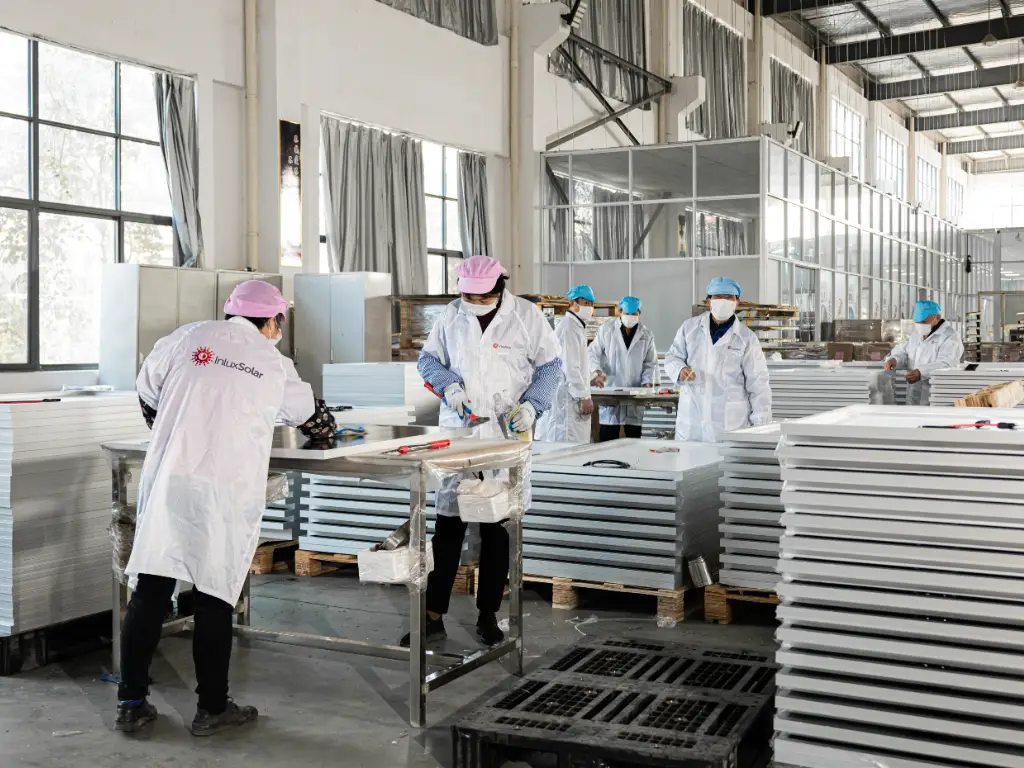 Photovoltaic panel production workshop, many workers are working on the production line